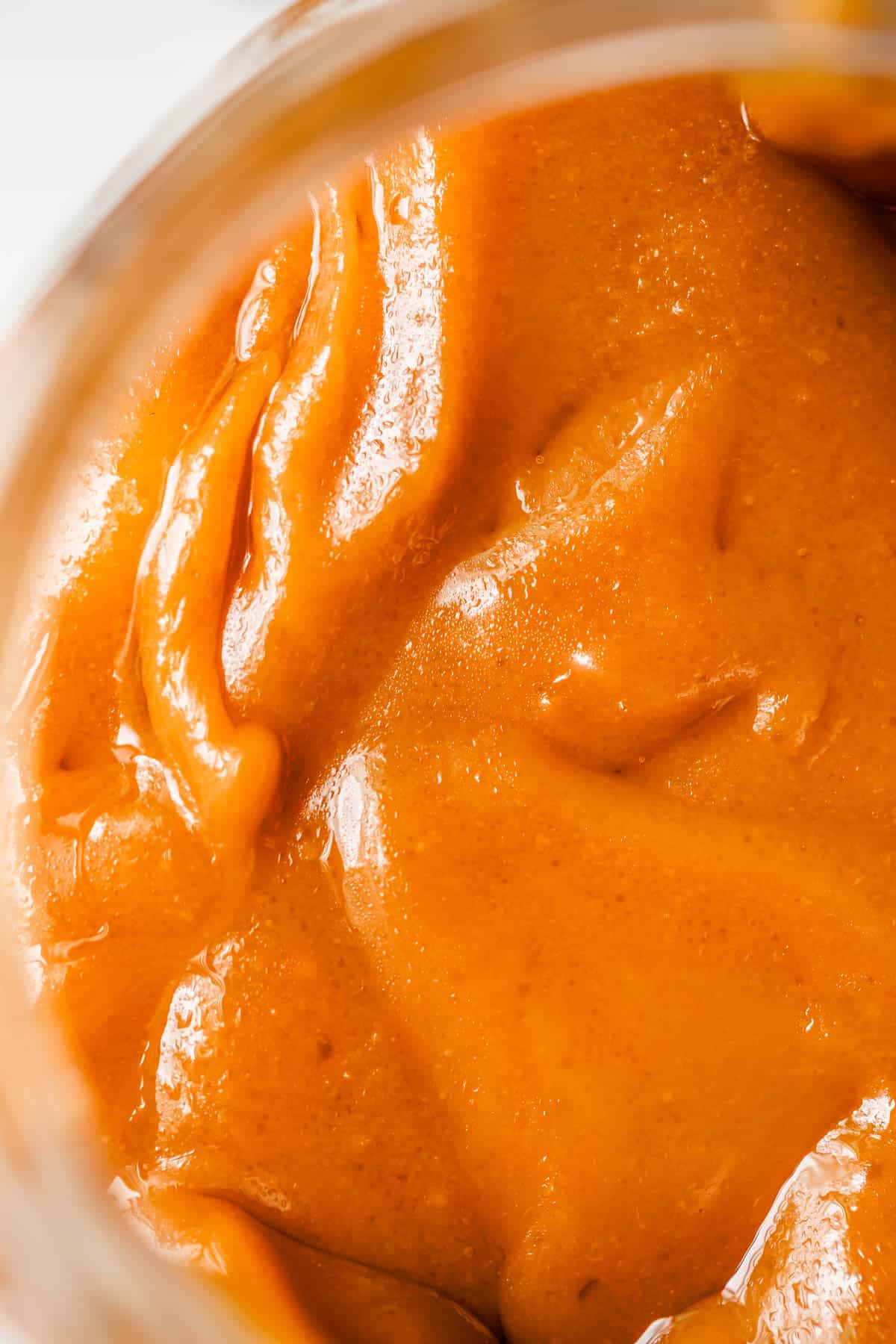close up of salted fudgy caramel in a glass jar.