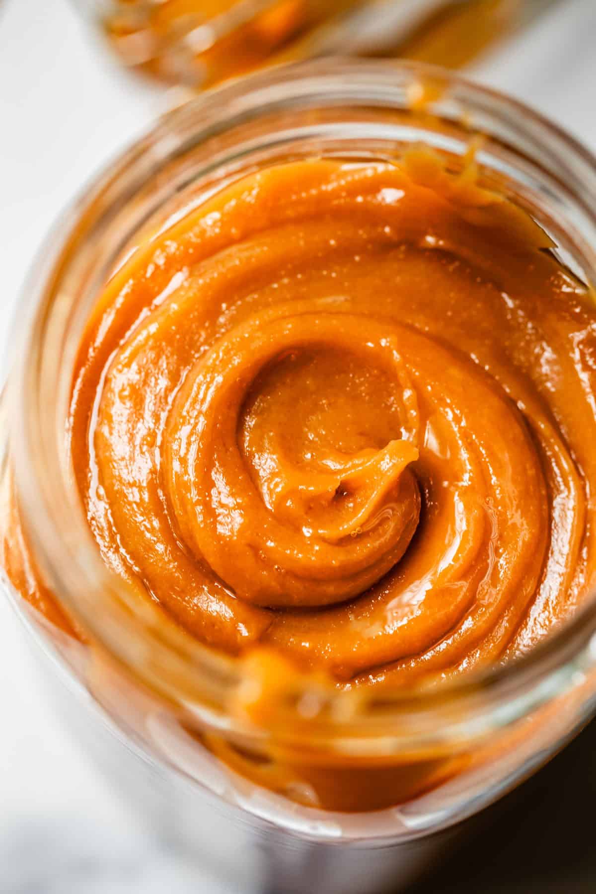 perfectly made and swirled cooled salted caramel in a glass mason jar.