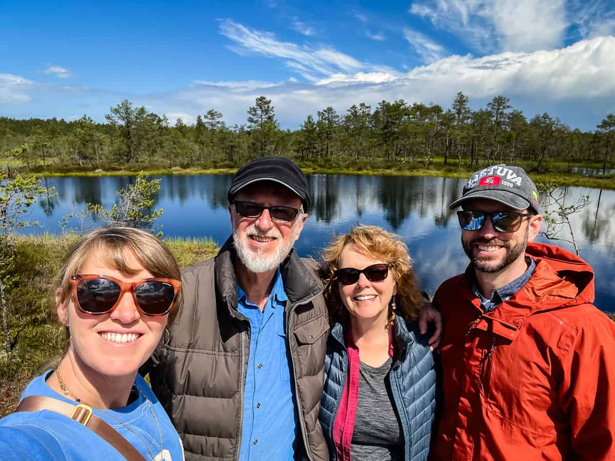 two couples standing by a lake.