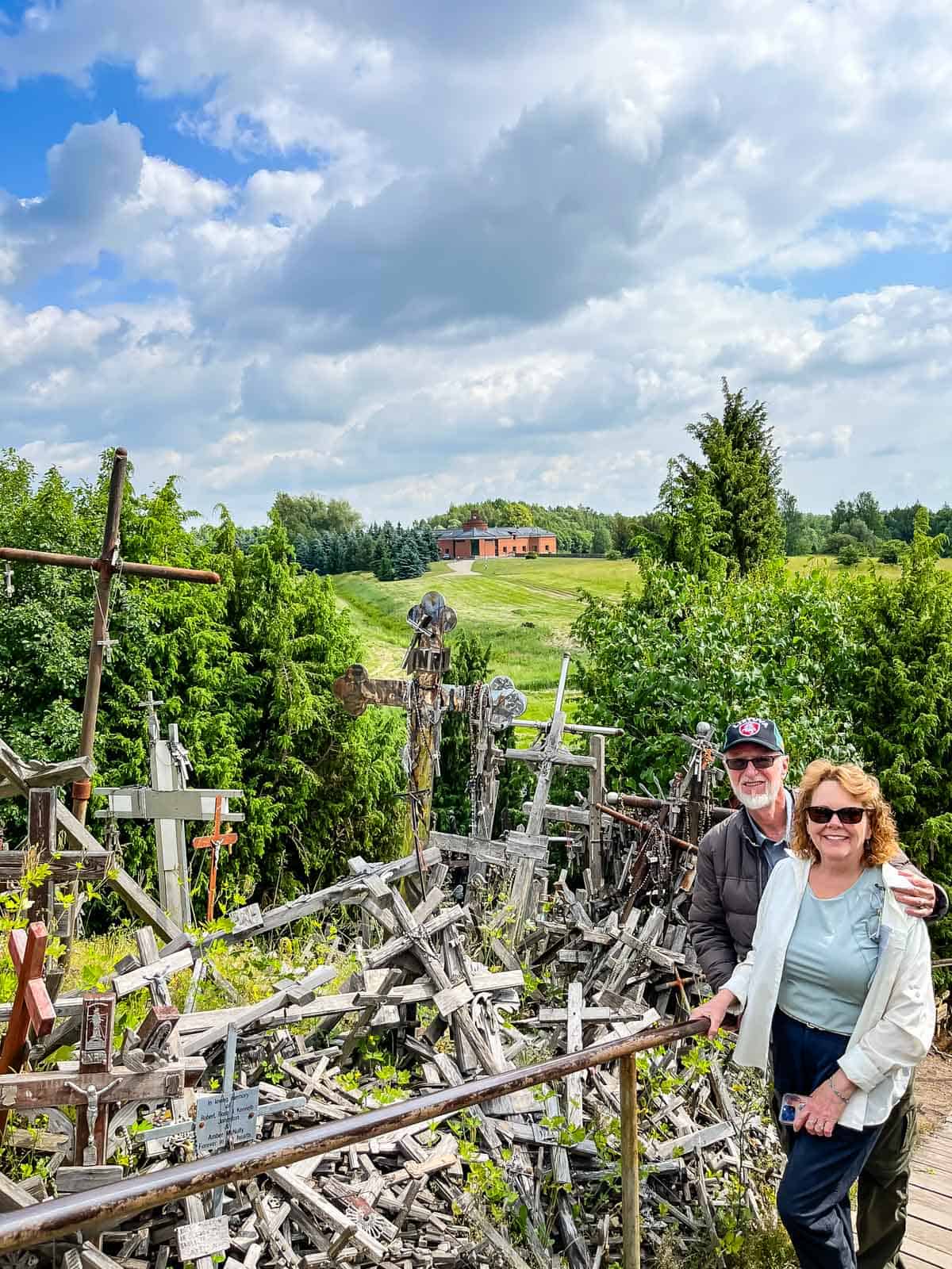 man and woman at hill of crosses in lithuania.
