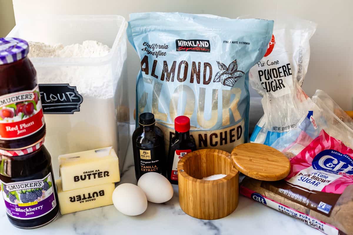 ingredients for linzer cookies like almond flour, regular flour, butter, eggs, and more.