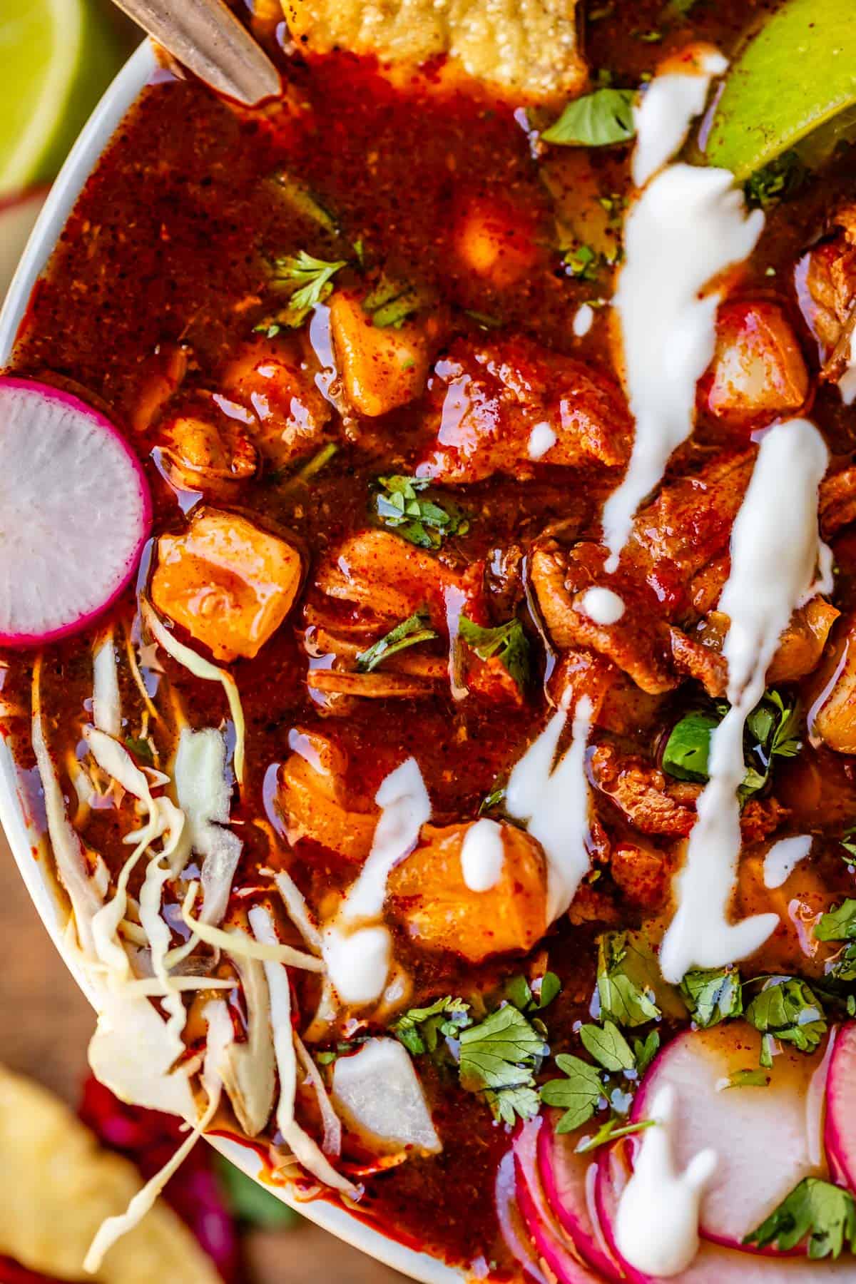 pozole rojo with radish, Mexican crema, lime, and thinly sliced cabbage toppings.