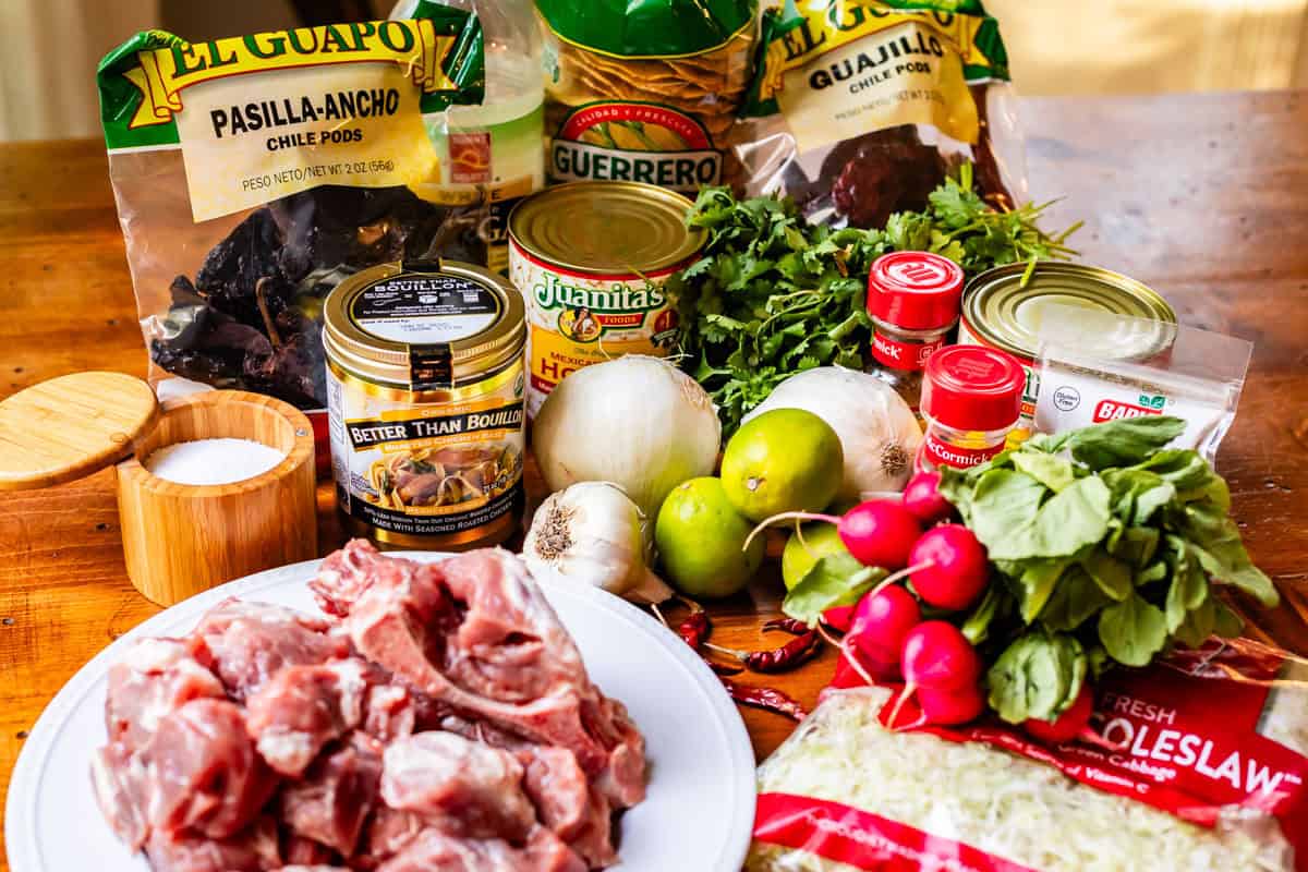 ingredients for pozole rojo like pork shoulder, hominy, dried red chiles, and more.