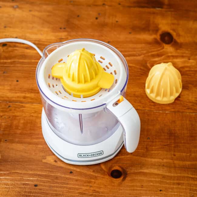 Electric juicer on wooden table.