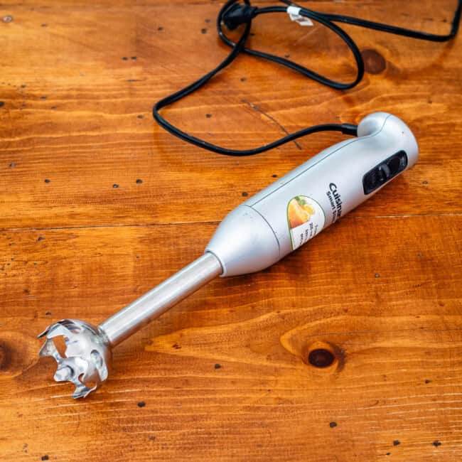 Cuisinart immersion blender on wooden table.