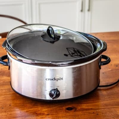 Crockpot slow cooker on wooden table.