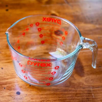 Pyrex 8-cup glass measuring cup on wooden table.