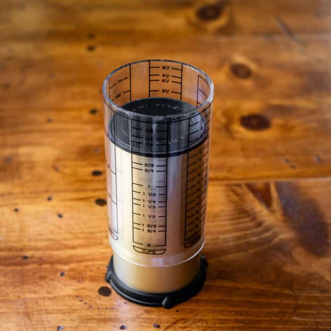 Adjustable measuring cup on wooden table.