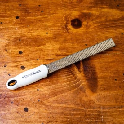 Microplane grater on wooden table.
