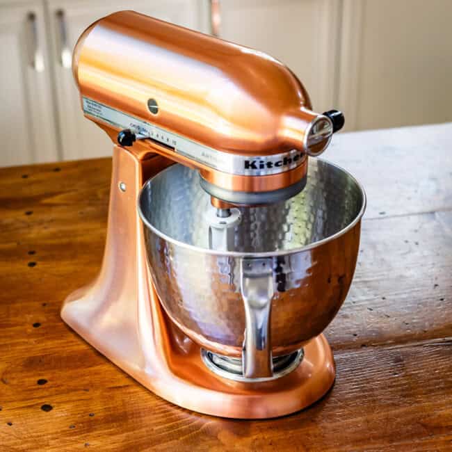 Copper kitchen air mixer on wooden table.