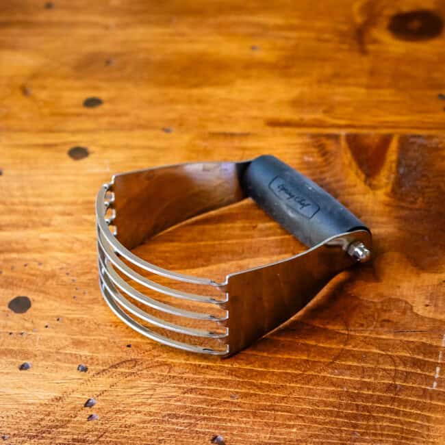 Metal pastry cutter on wooden table.
