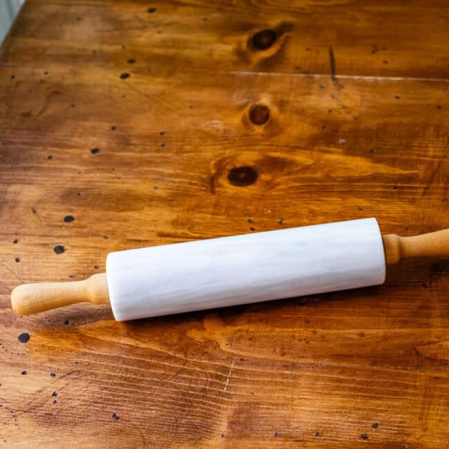 Marble rolling pin on wooden table.