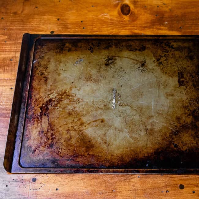 Flat baking sheet 14" x 17" calphalon on wooden table.