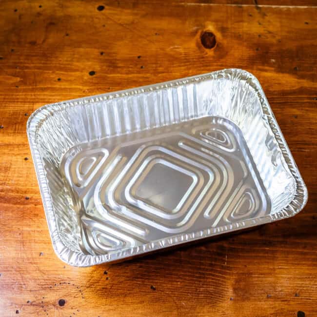 Aluminum takeaway casserole dish on wooden table.