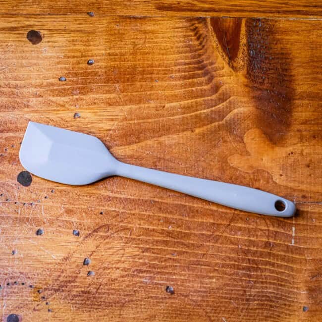 Small rubber spatula on wooden table.