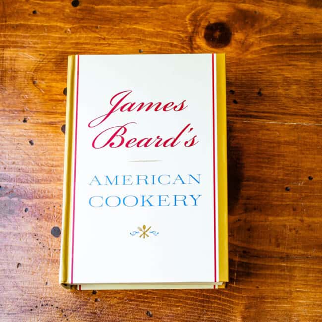 Copy of cookbook Jame's beard's American Cookery on wooden table.