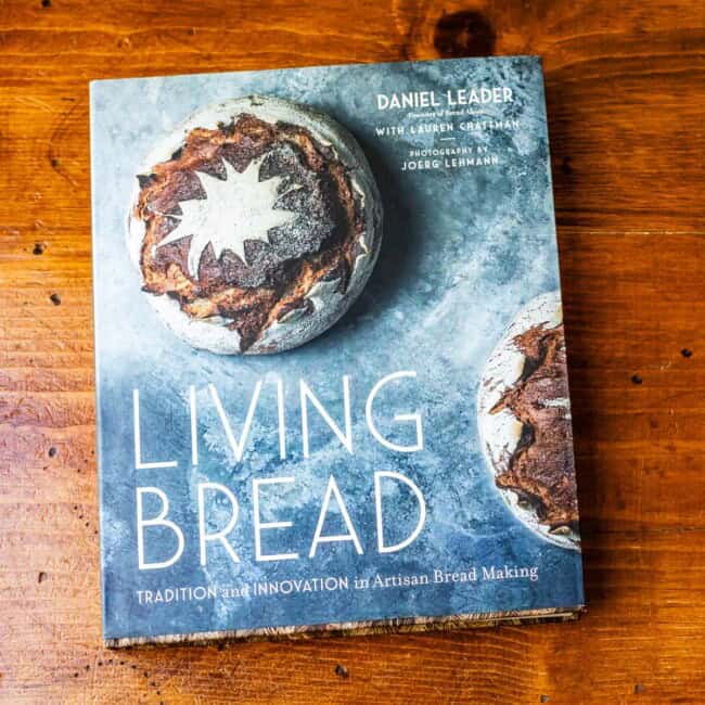 Copy of cookbook living bread by Daniel Leader on wooden table.