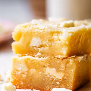 side view of two stacked square piece of white chocolate brownies.