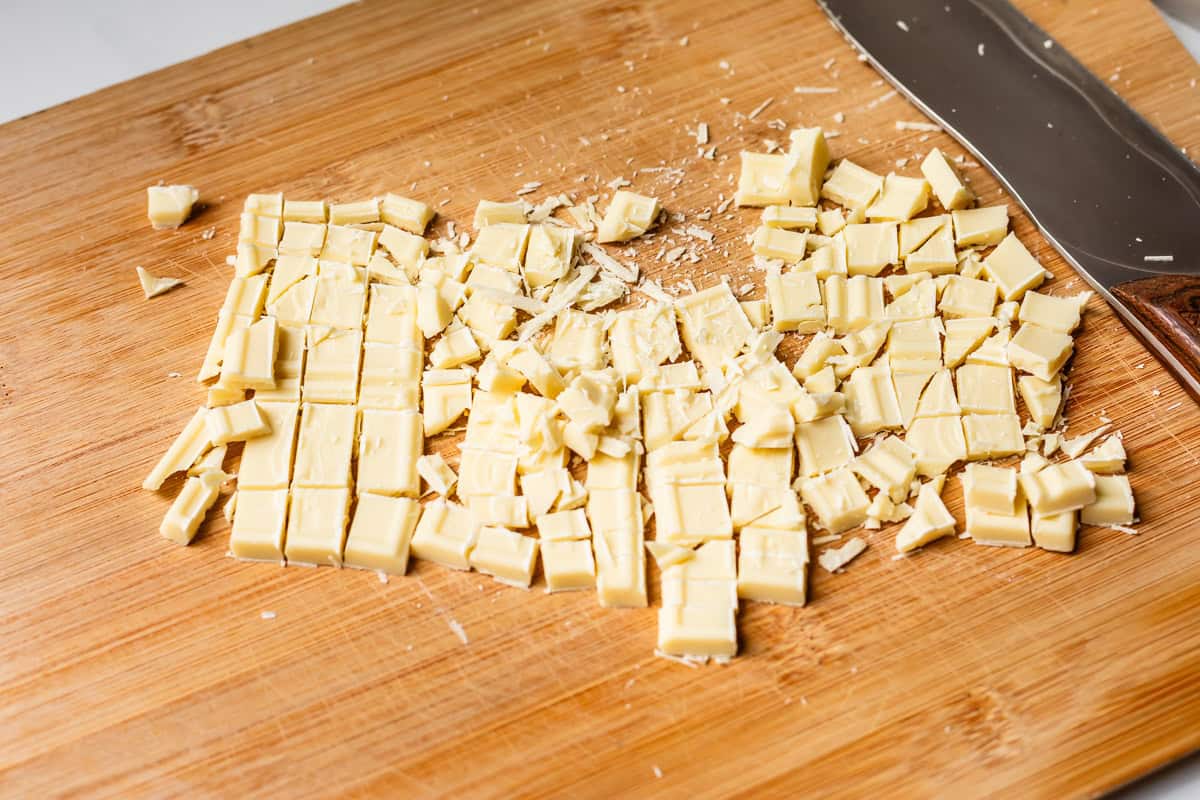 Chopped white chocolate on a cutting board.