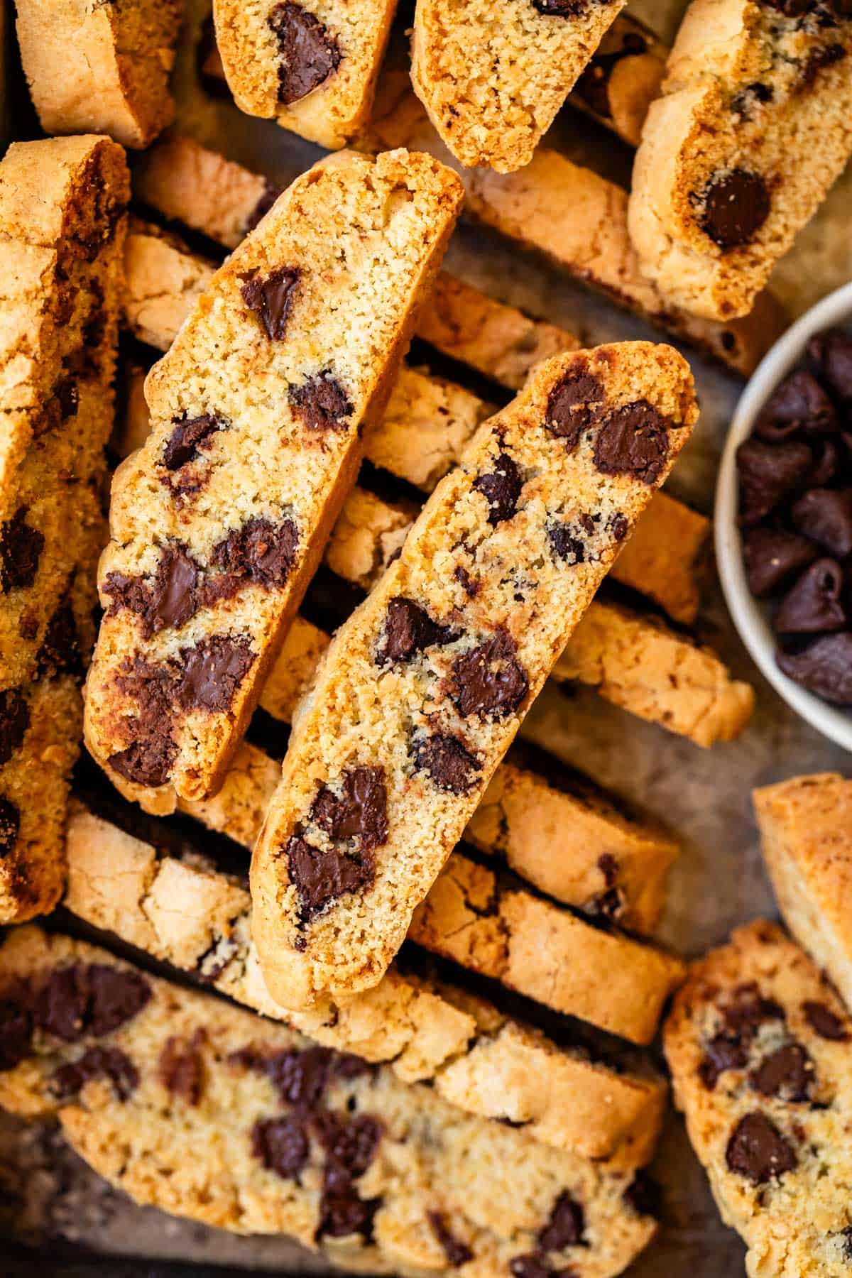 a few biscotti cookies showing all the chocolate sitting on top of a stack of biscotti.