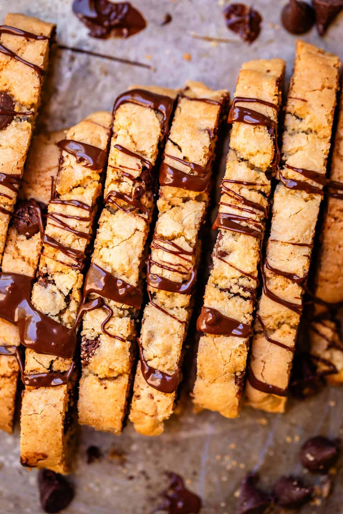 top edges of several biscotti next to each other with chocolate drizzled over the top.