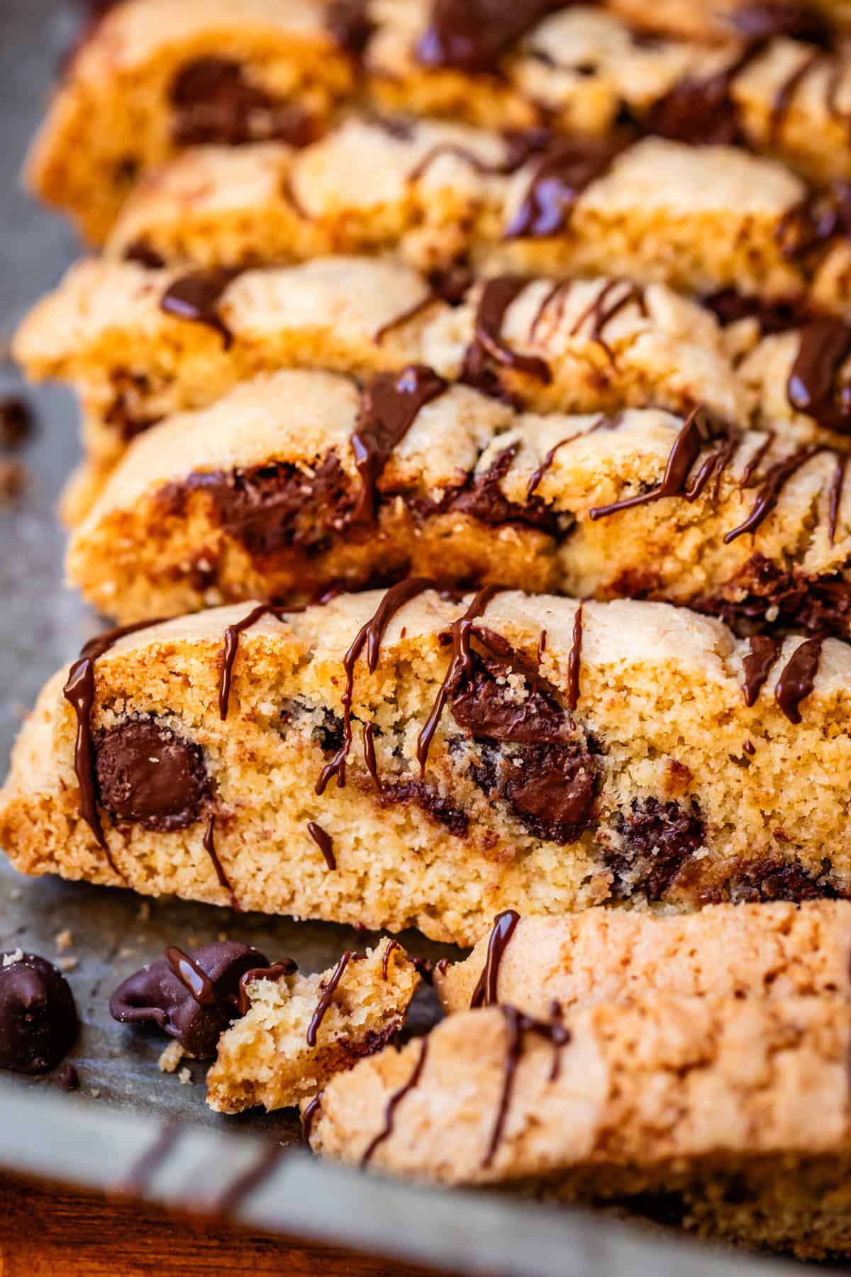 several chocolate drizzled biscotti cookies on a metal baking sheet.