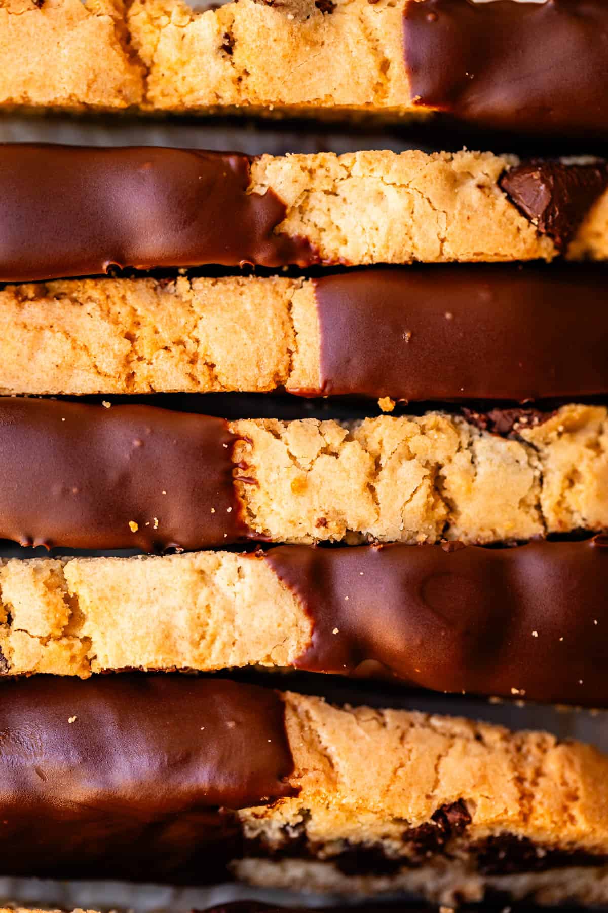 looking down at the top of several biscotti cookies that have one end dipped in chocolate.