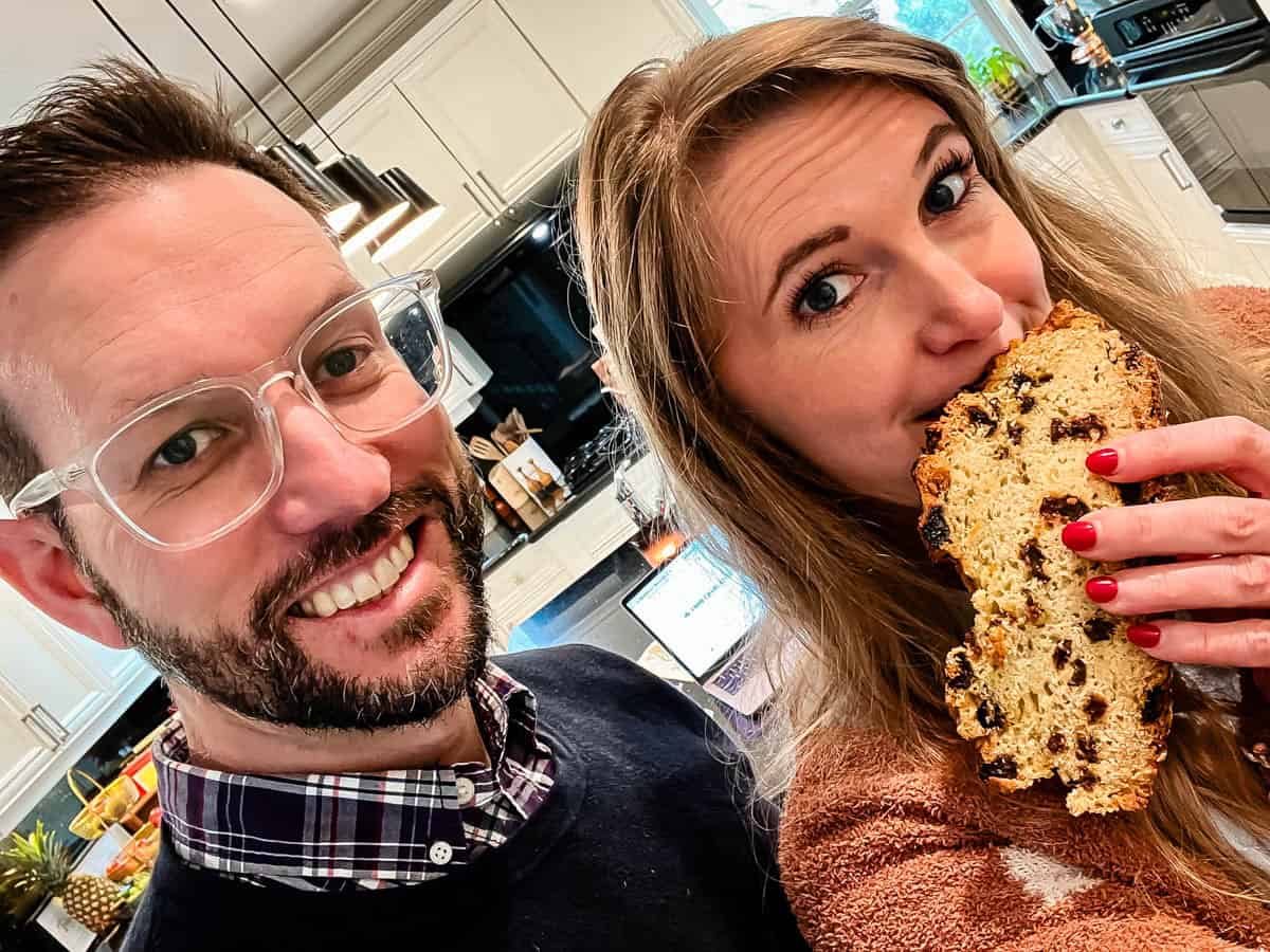 man and woman in kitchen holding Irish soda bread with riasins.