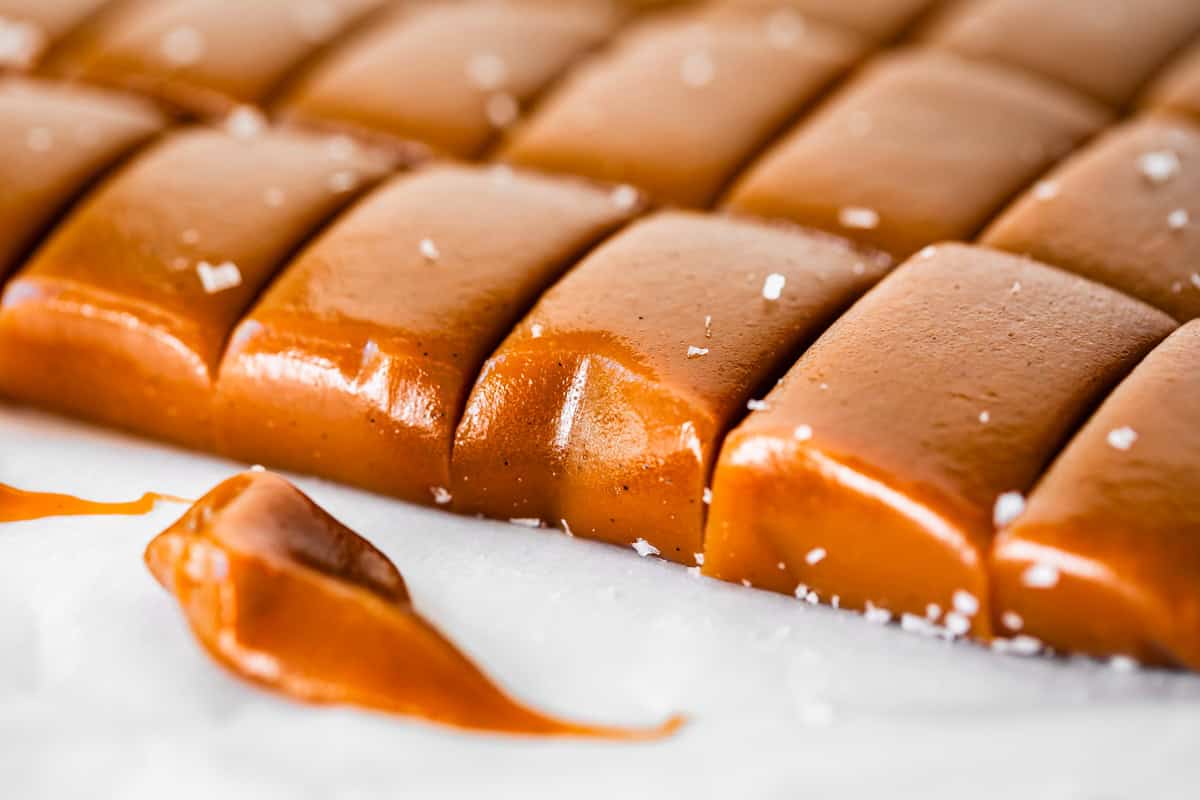 a block of soft, chewable caramel candy with slices cut into it, topped with salt.