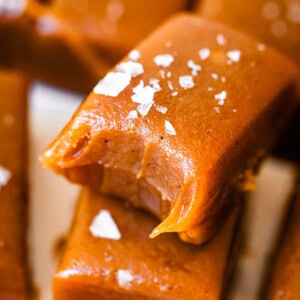 soft, salted caramel candy rectangle with a bite taken from it, stacked on another rectangle.