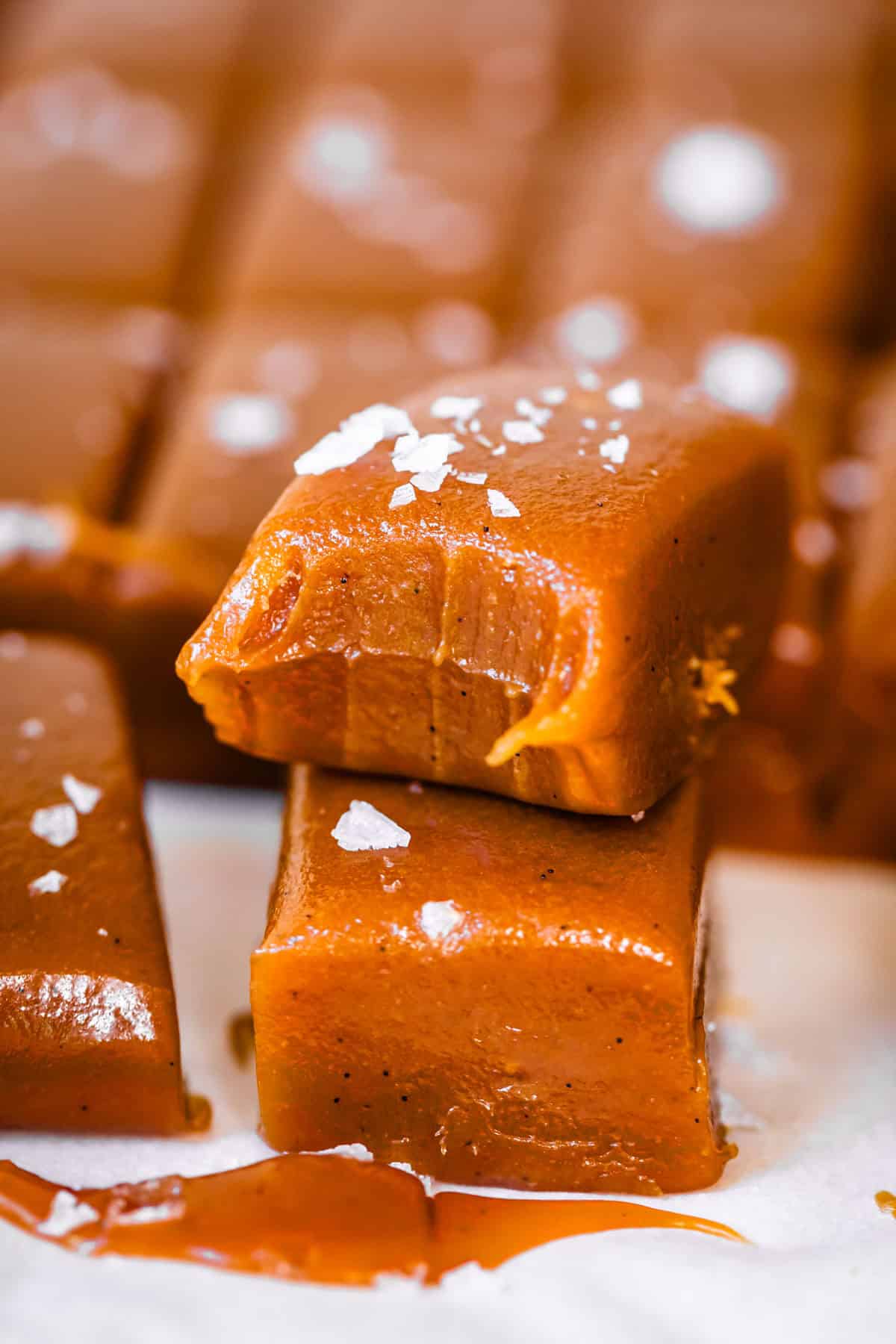 Bite taken out of a caramel stacked on top of another, both made with evaporated milk.