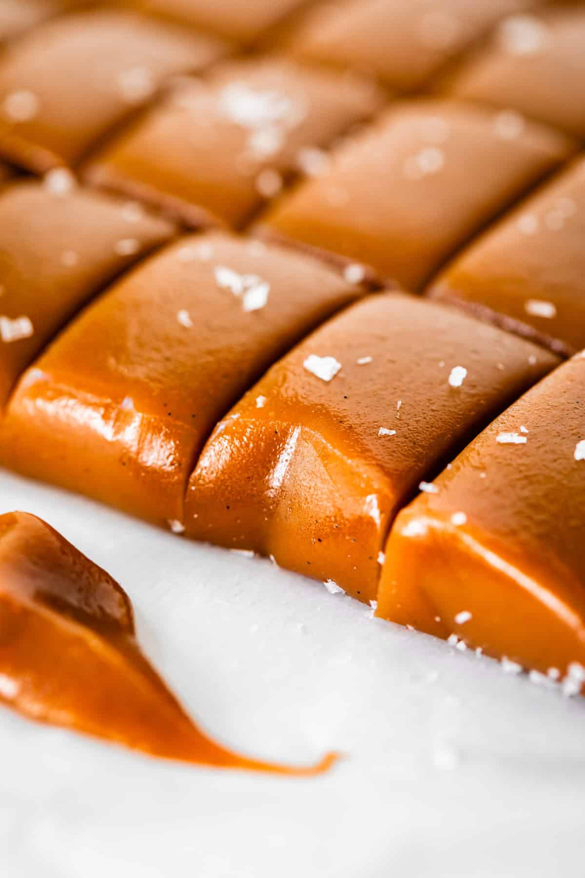 edges showing the firm, but chewable soft caramel candy cut into rectangles.