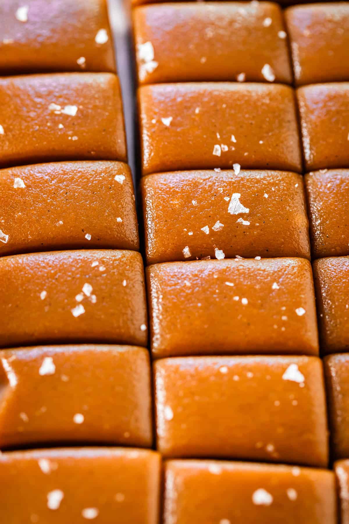Soft caramel candy still in a slab, but with slices cut to separate into pieces.