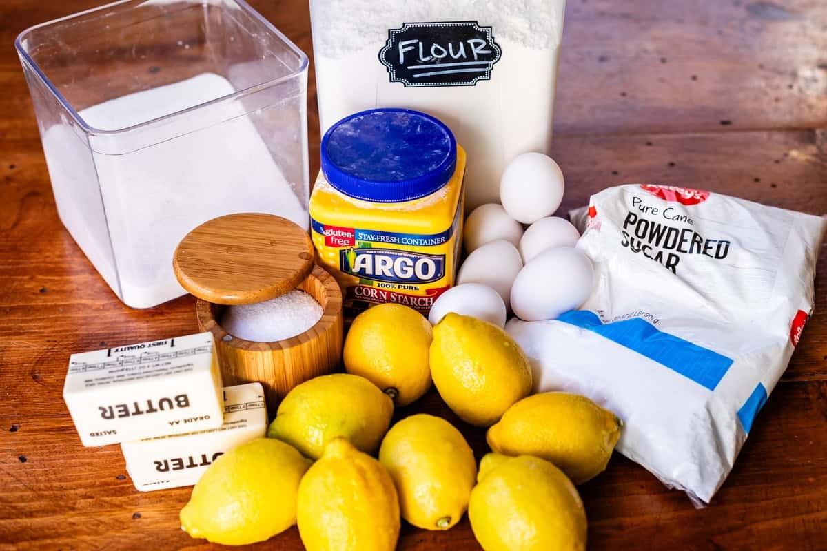 ingredients for lemon bars like lemons, powdered sugar, eggs, flour, and more.