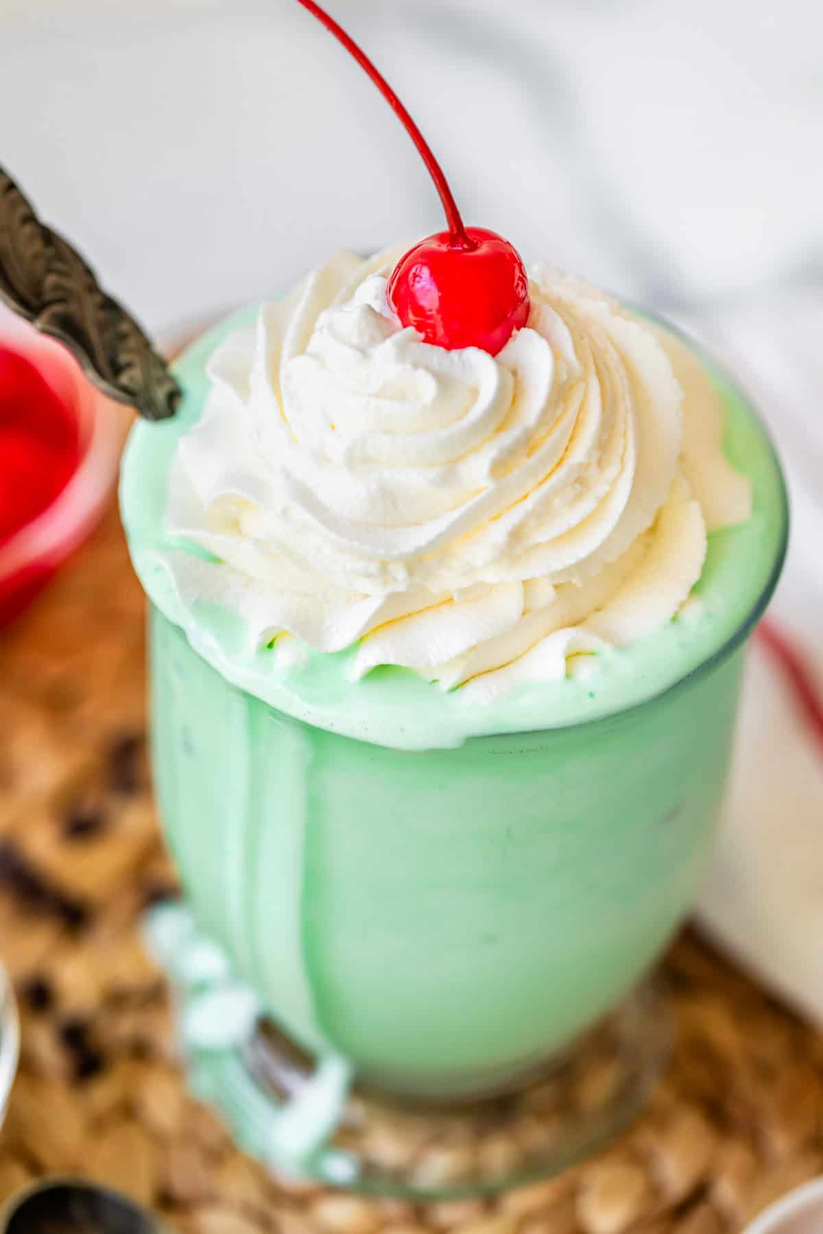 glass filled with shake and topped with piped whipped cream, and a cherry.