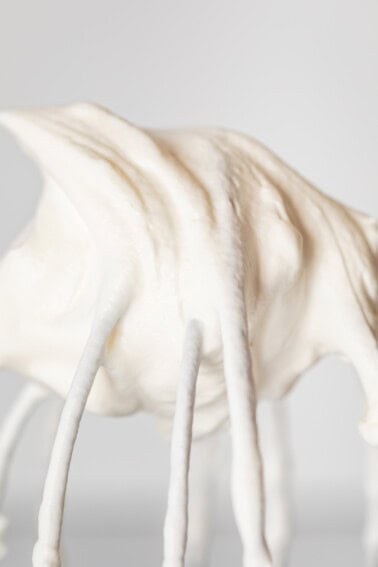 close up of whipped cream in a stiff peak on a whisk attachment.