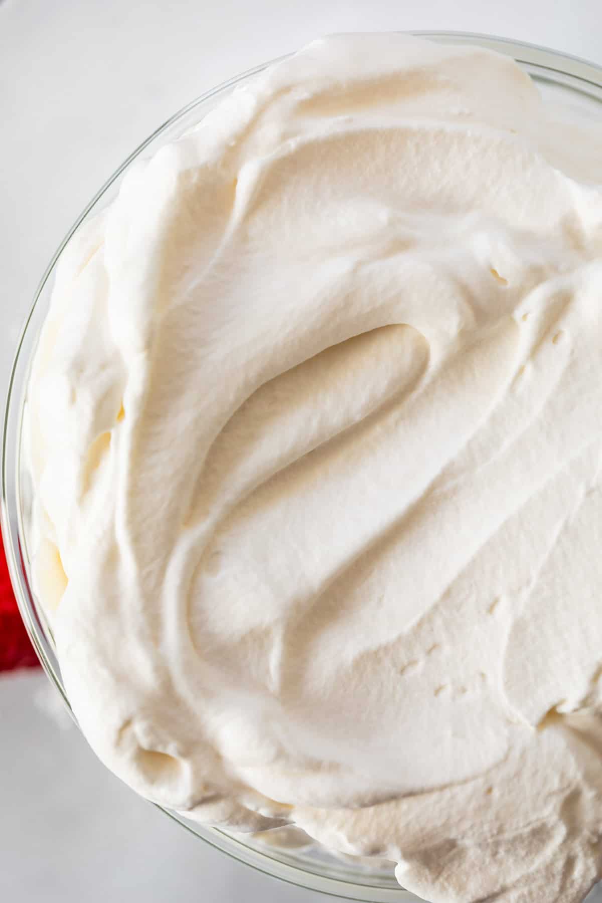 looking down on a glass bowl of whipped cream with a smoothed top.