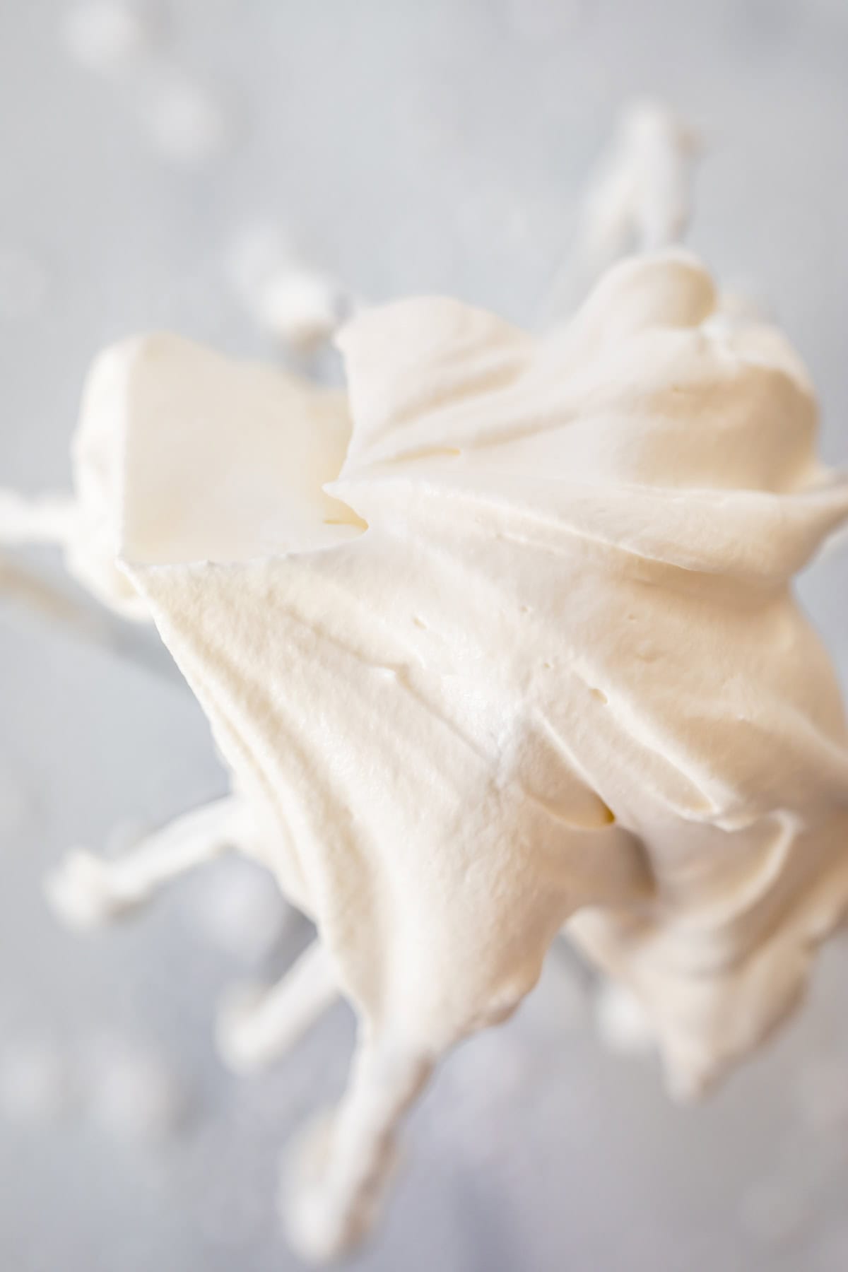 looking straight into the peak of stiff whipped cream at the end of a whisk.