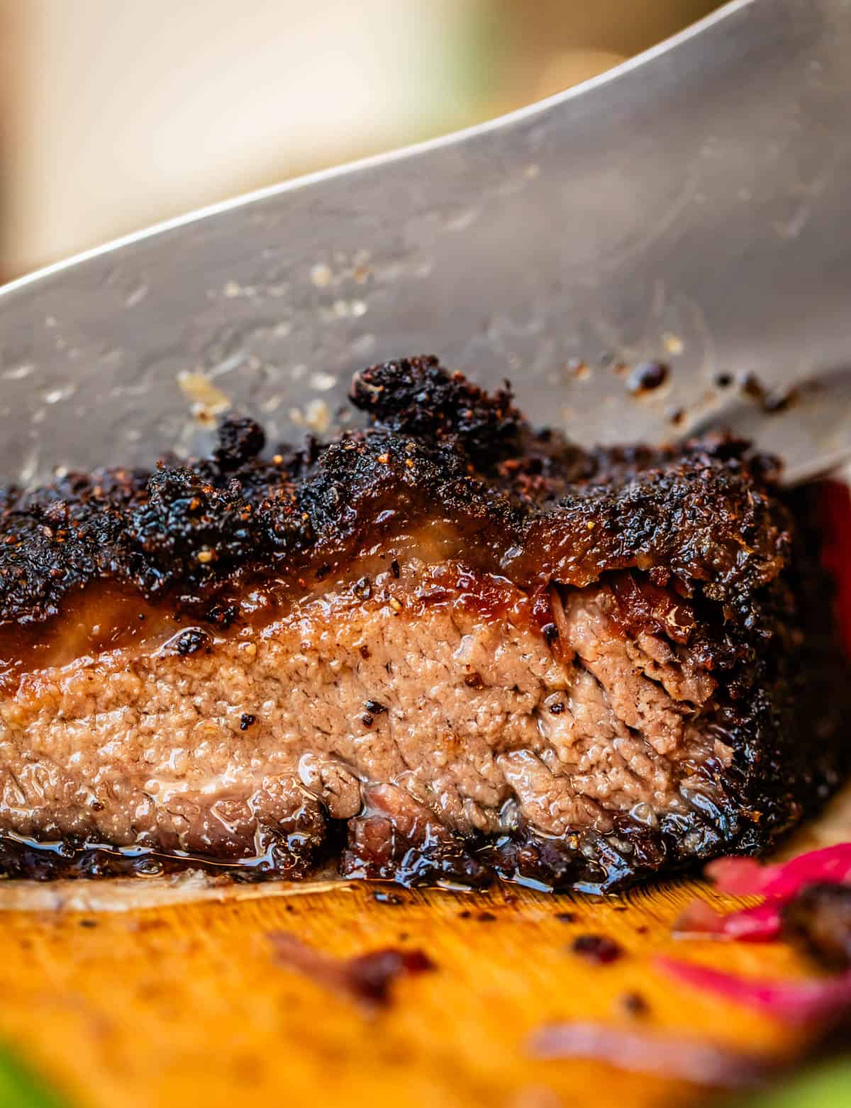 Slicing through moist beef brisket with charred fat cap.