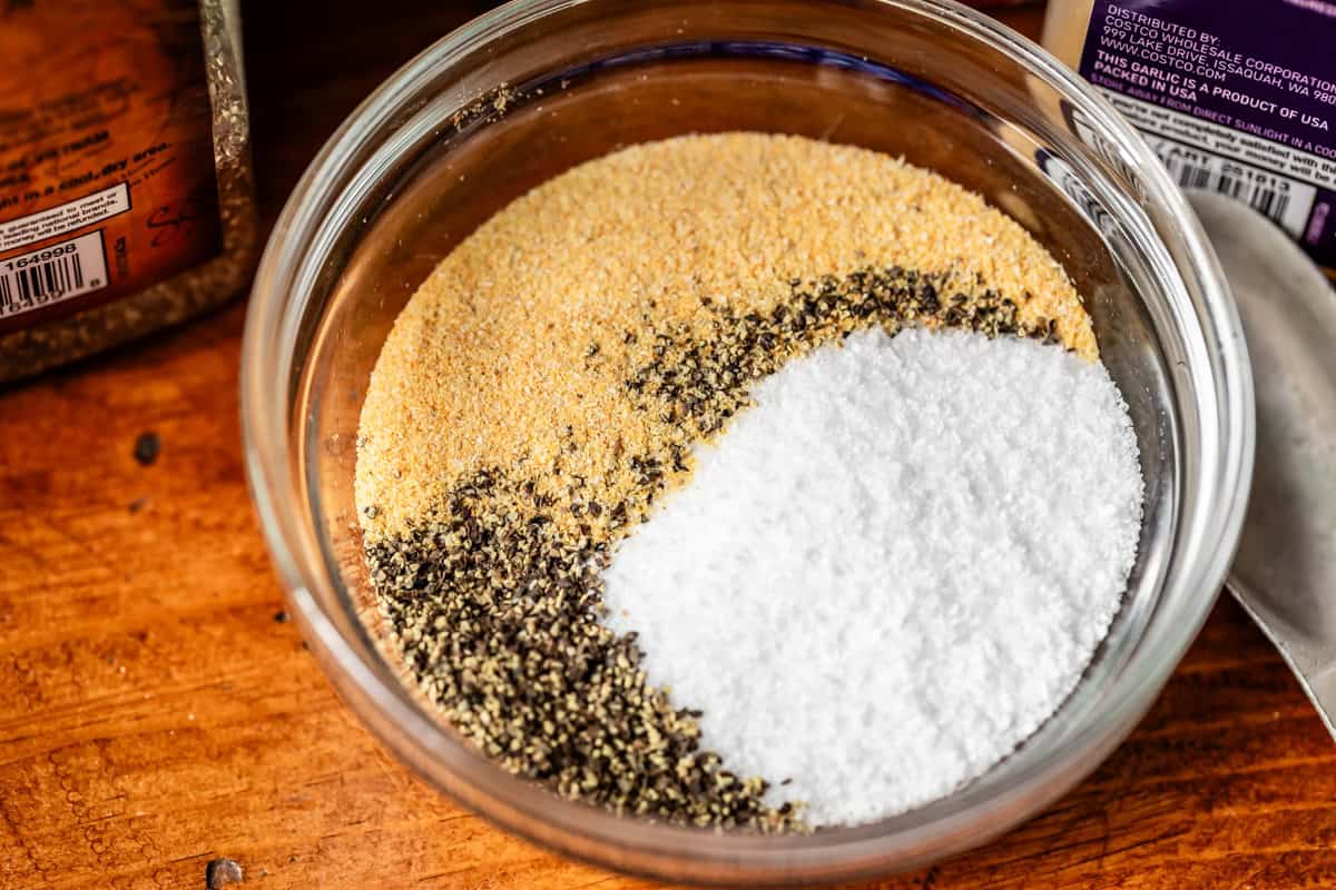 small glass bowl filled with salt, pepper, and garlic granules for the dry brine.