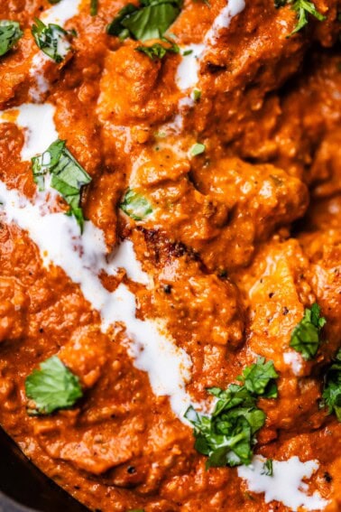 close up of chicken tikka masala with cream and parsley garnish.