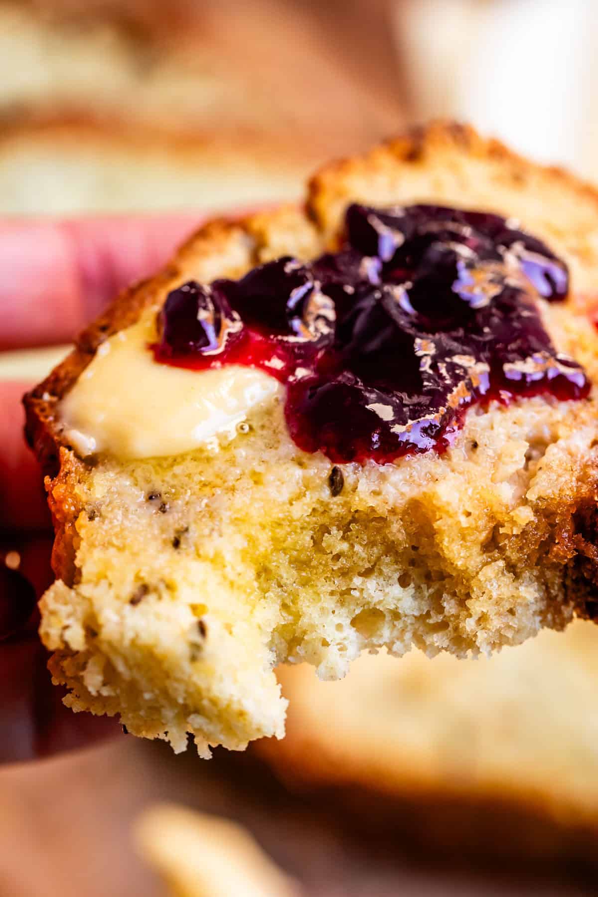 Close up of Irish soda bread with butter and blackberry jam spread on top.