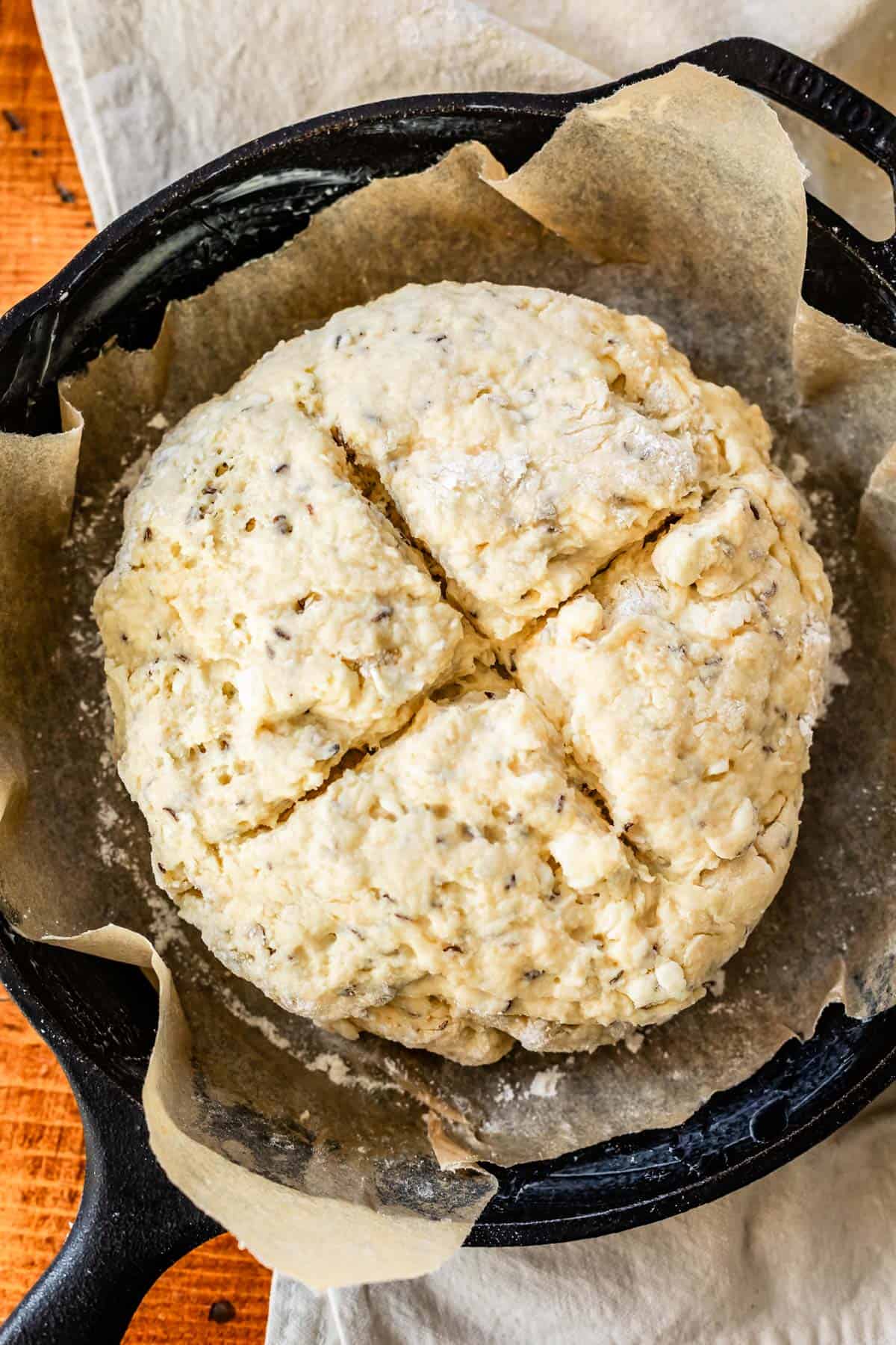 raw Irish soda bread with an X cut in the top.