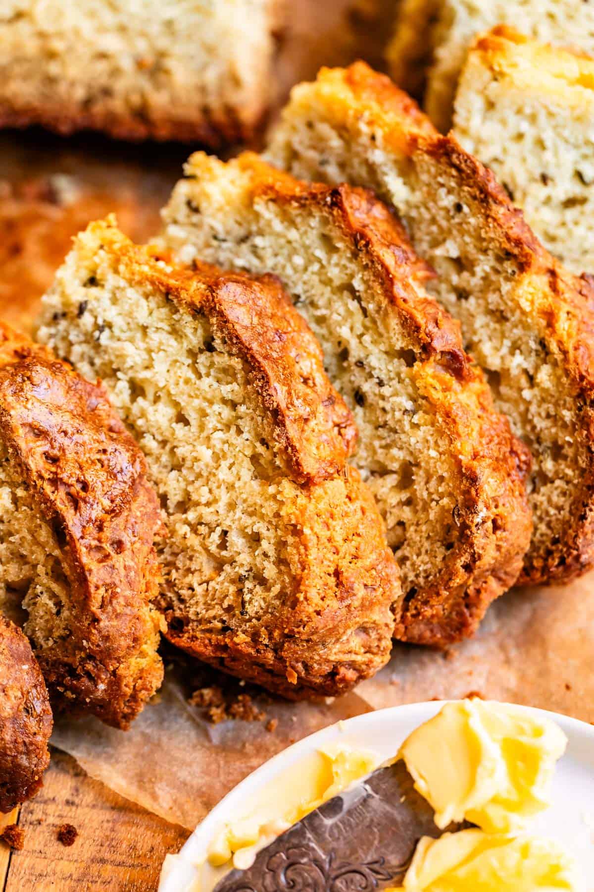 Slices of Irish soda bread nested over each other with butter in the foreground.