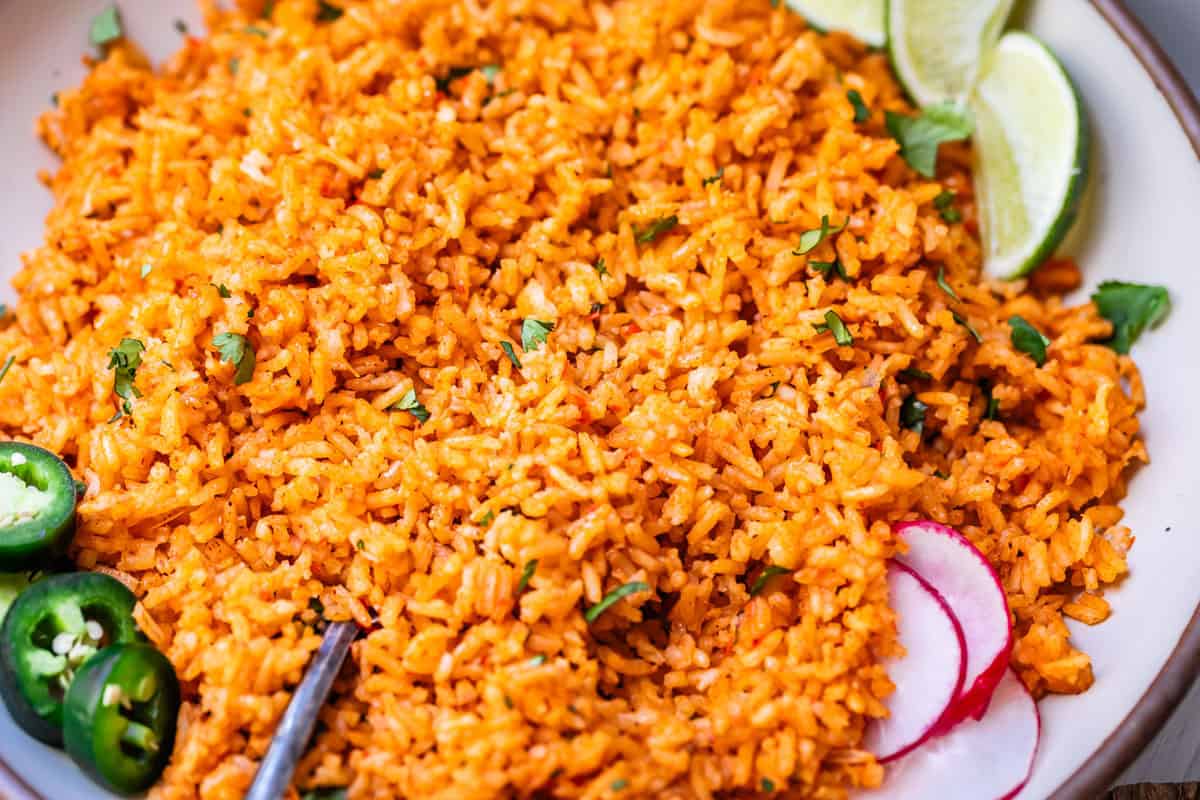 large dinner plate filled with Mexican rice and garnished with radishes, lime, and jalapeno.