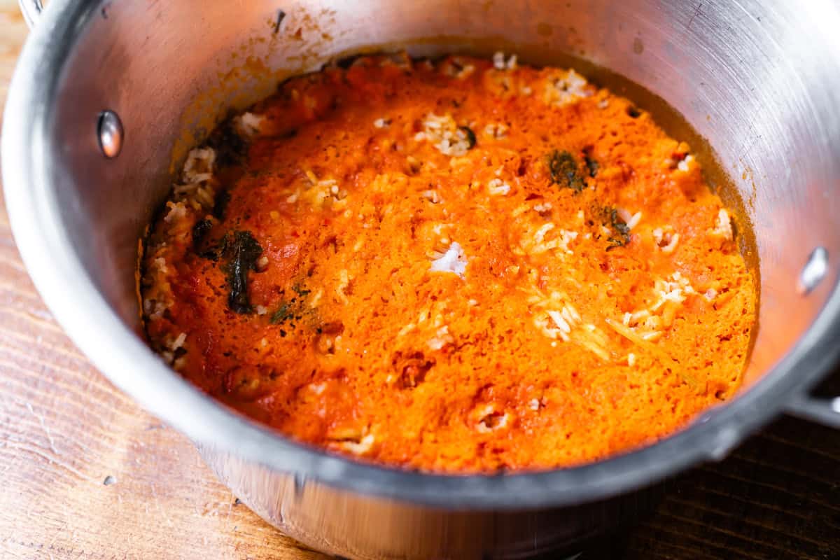 cooked Mexican rice in pot with a lot of the sauce sitting on the top of the rice.