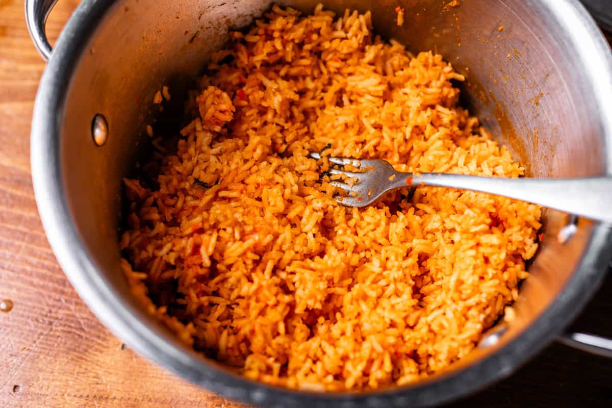 fork in metal pot and completely fluffed rice ready to serve.