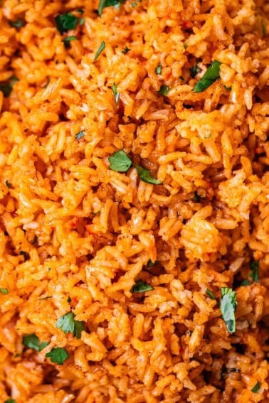 close up showing the detail of Mexican rice cooked in a super flavorful tomato sauce.
