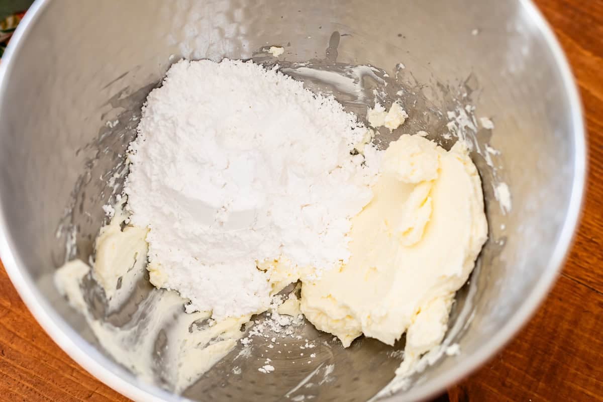 mixing cream cheese a powdered sugar in a bowl.